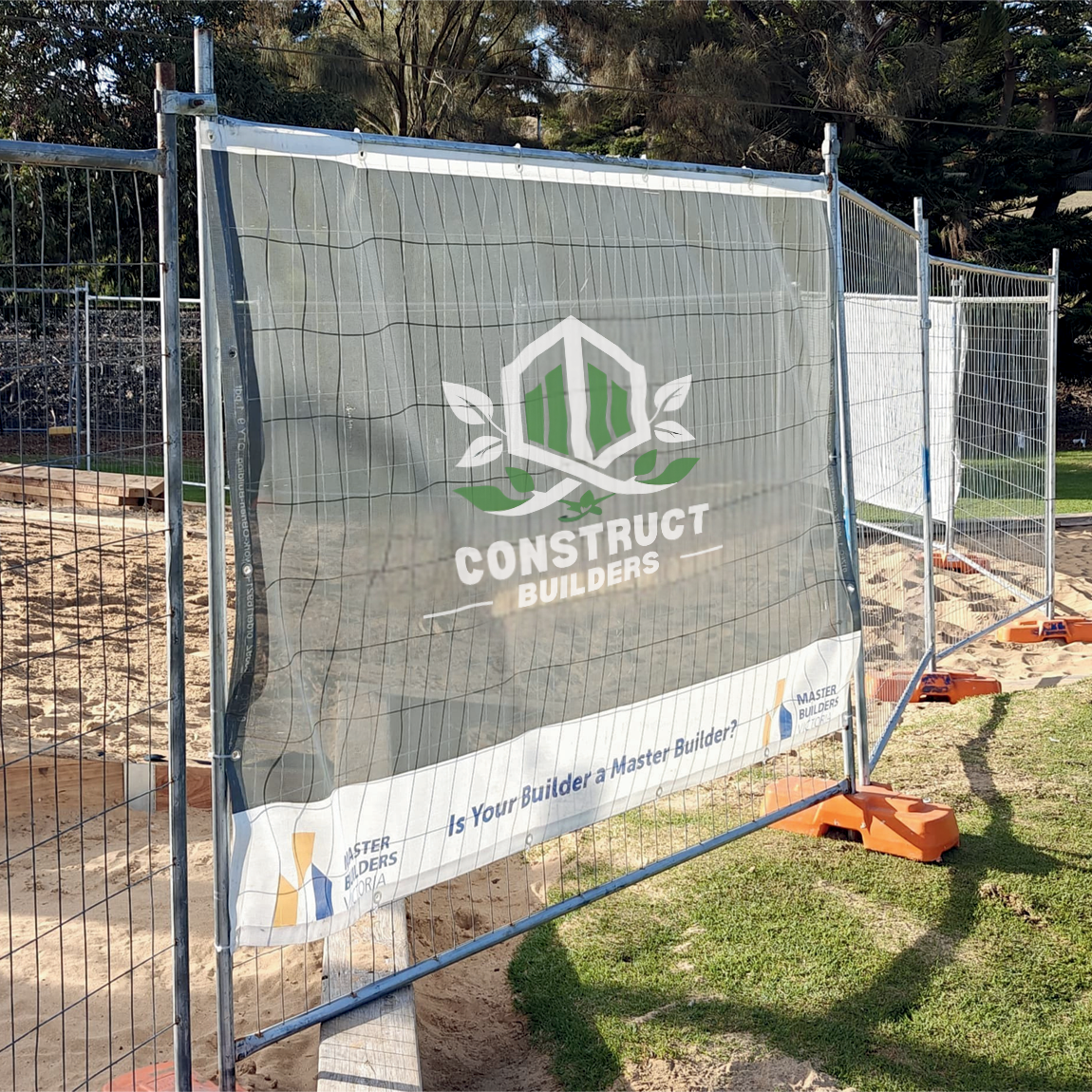 Construction site mesh banner with a branded safety fence displaying 'Construct Builders' logo.
