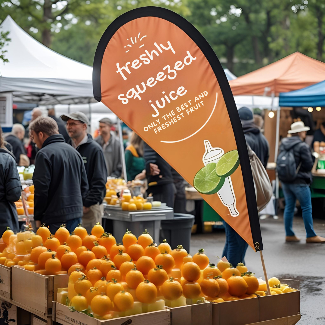 Freshly squeezed juice stand with oranges at an outdoor market.