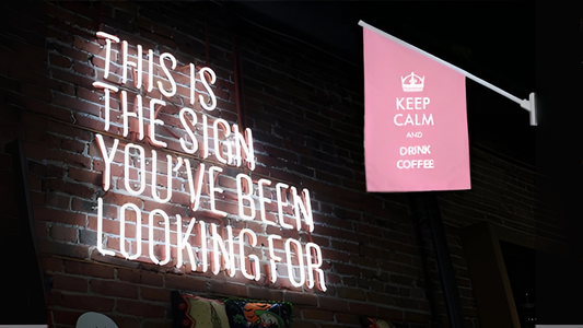 An end sign flag floating next to a neon sign that says "This is the sign you've been waiting for".