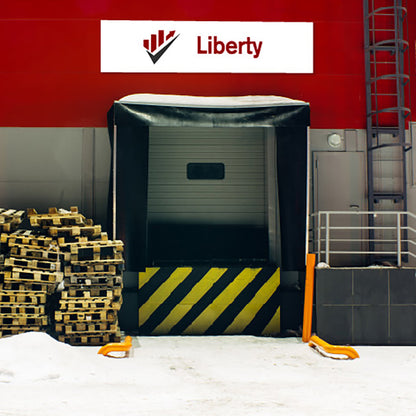 Dock with a covered door, pallets, and a Liberty logo sign on aluminium composite panel on a red wall.